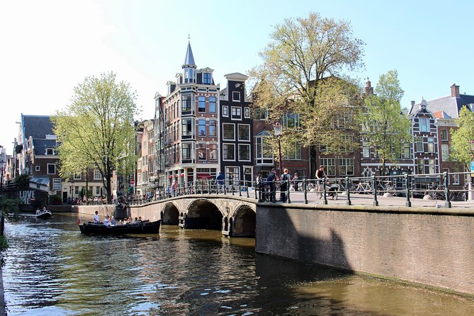 Amsterdam Canal Tour by Open Boat – 90 min Small Group Experience - Medieval locks, warehouses, and De Waag